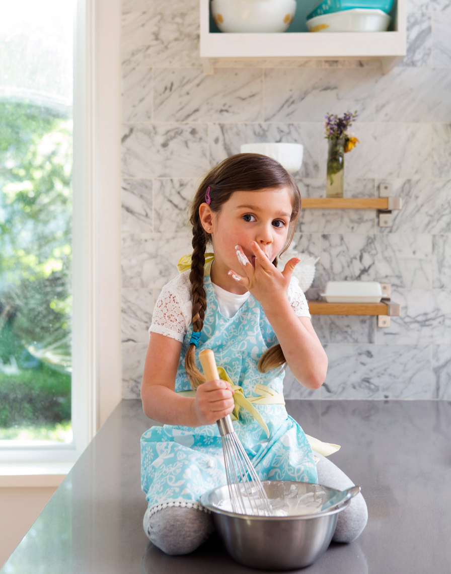 Girl with whipped cream  sitting on kitchen counter