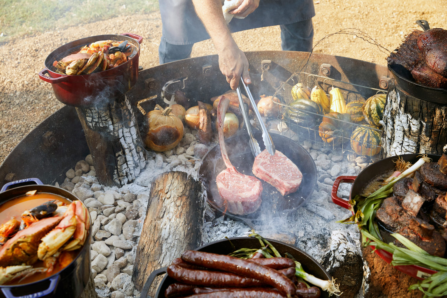 Cooking steaks over an open fire pit Driftwood texas