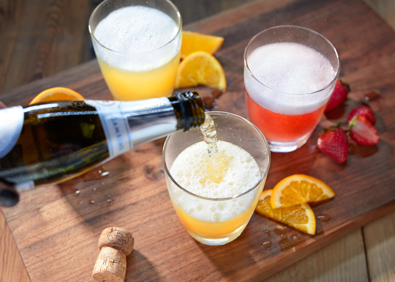 Pouring Mimosas on rustic table by food photographer Buff Strickland