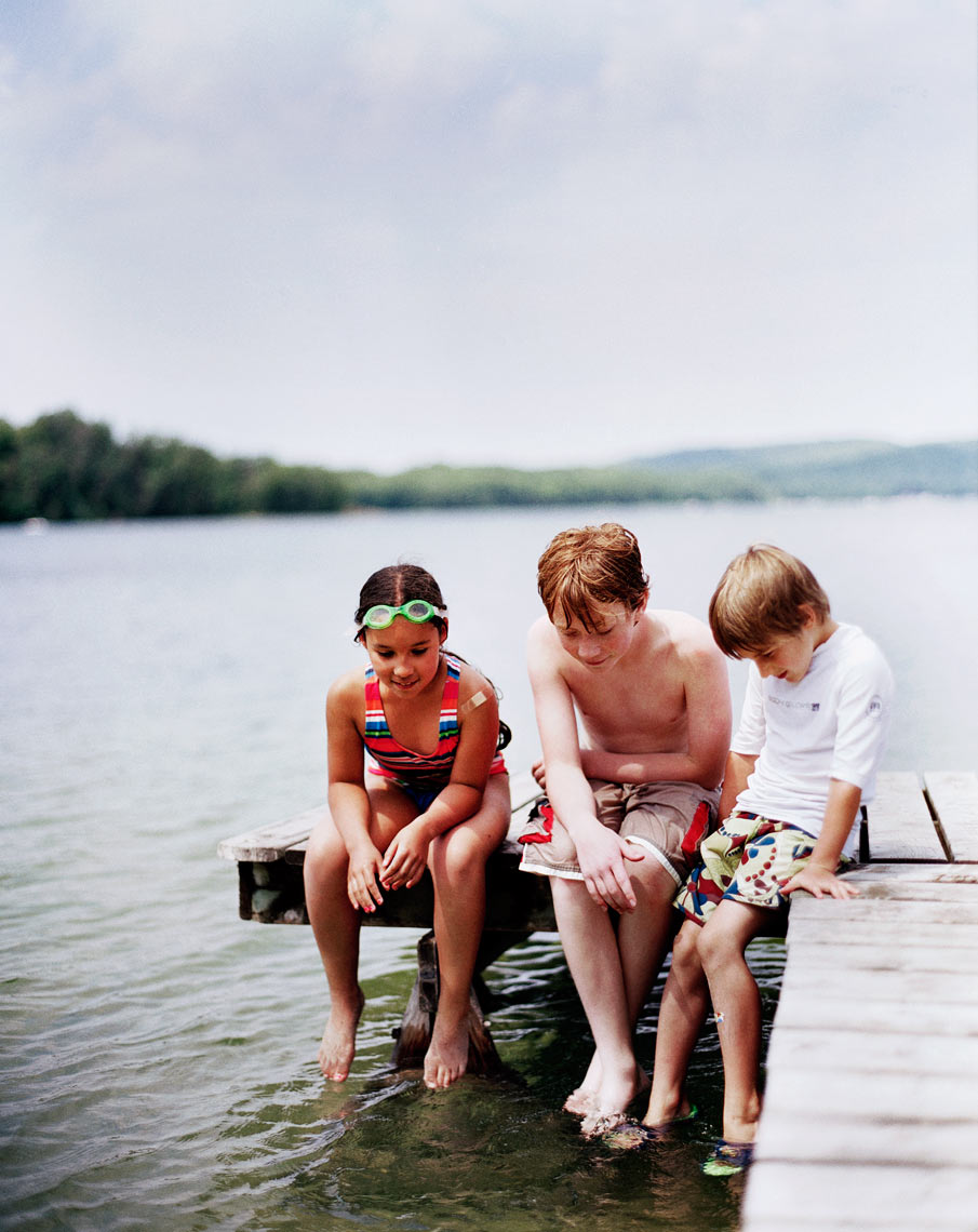 three kids on dock looking at water family summer travel