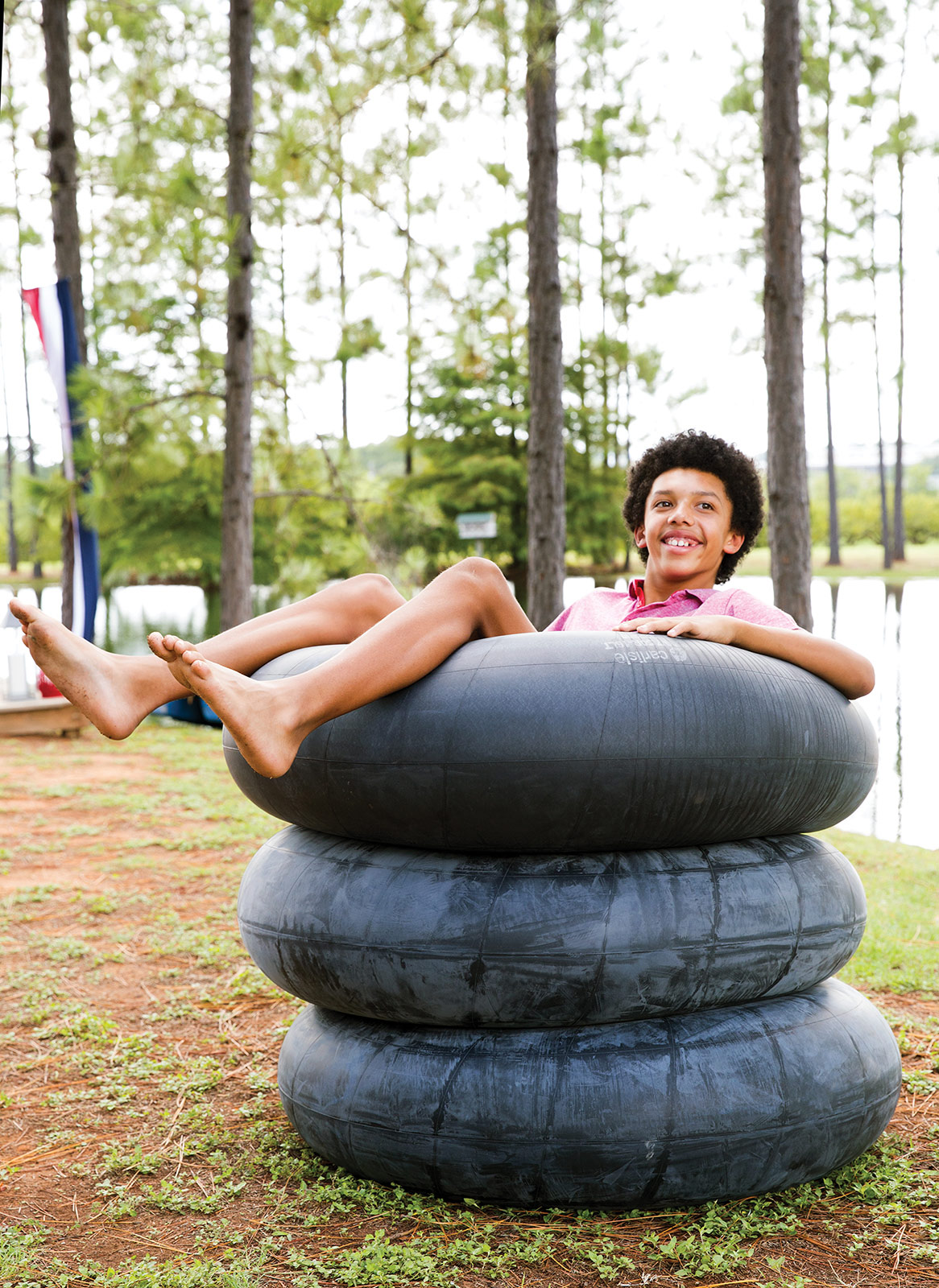 Teenager in inner tube on a summer day by Austin based photographer Buff Strickland