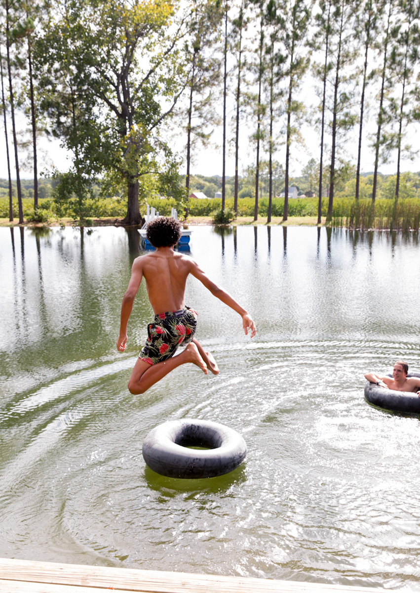 Fredericksburg, Texas boy jumping into a lake on a summer day but lifestyle photographer Buff Strickland