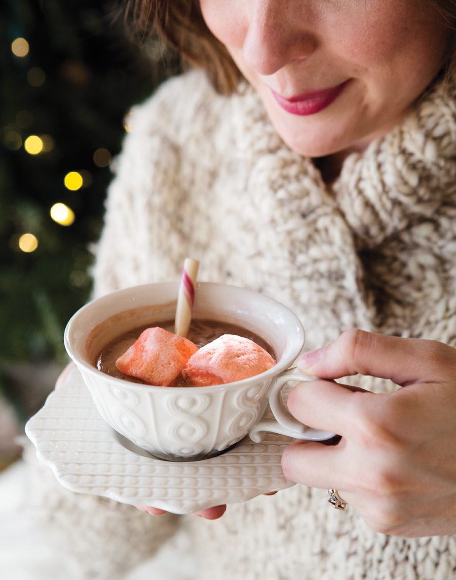 Camille Styles book hot chocolate with peppermint in warm white sweater at Christmas