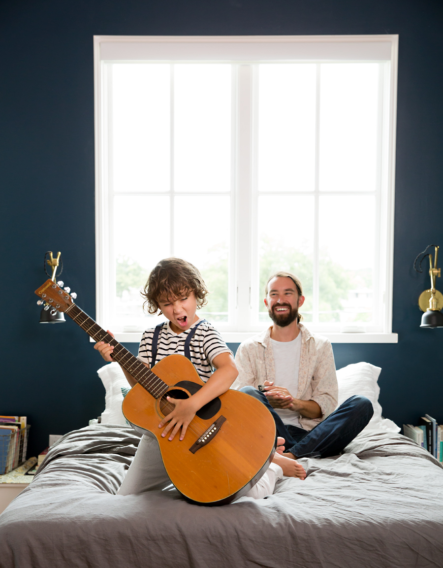 Dad and son at home playing guitar and laughing by lifestyle photographer Buff Strickland
