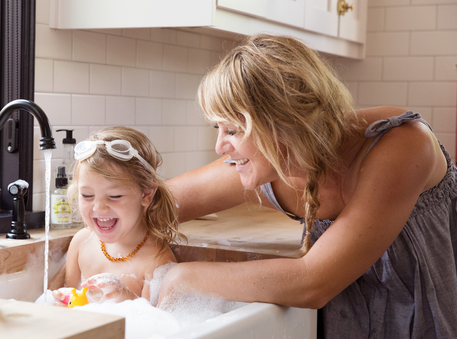 Mom and daughter taking bubble bath in sink by lifestyle photographer Buff Strickland