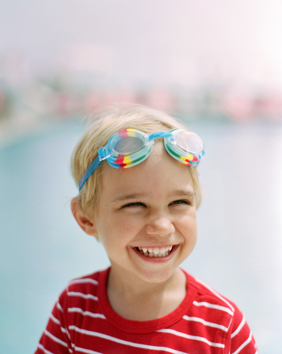 Little boy in bright red stripes wearing goggles by lifestyle photographer Buff Strickland