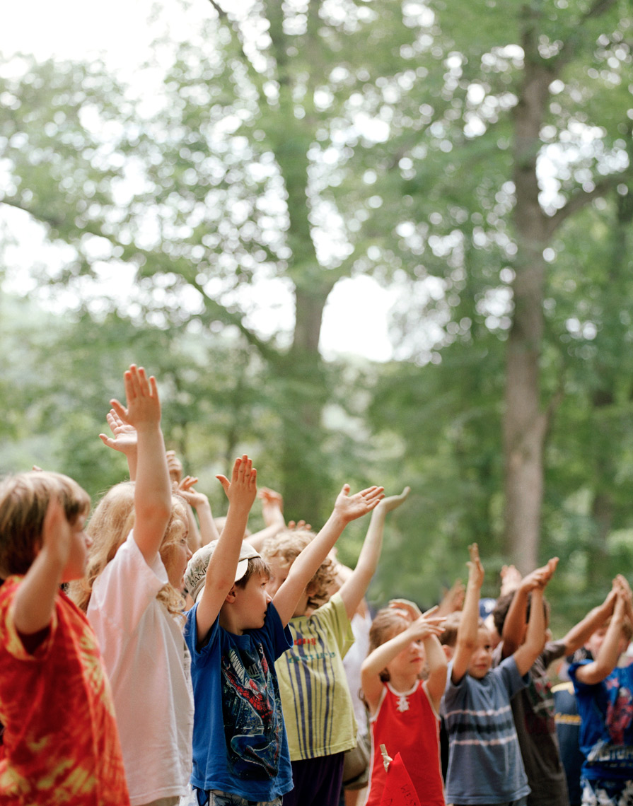 kids in summer camp raising hands in here