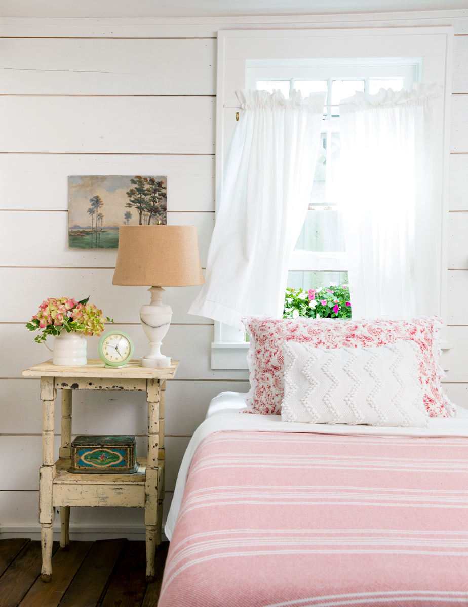 Farmhouse style pink bed by window by interior photographer Buff Strickand